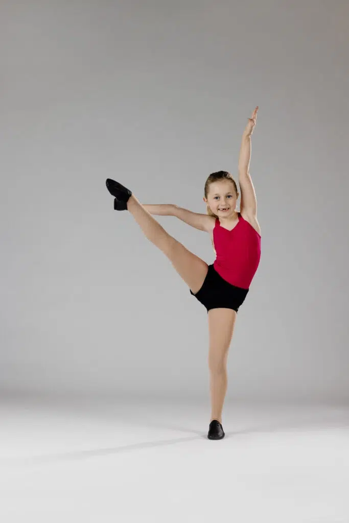 Bayside A young jazz dancer shows strength and flexibility in a high kick pose. Jazz dance classes for kids in Wynnum-Manly